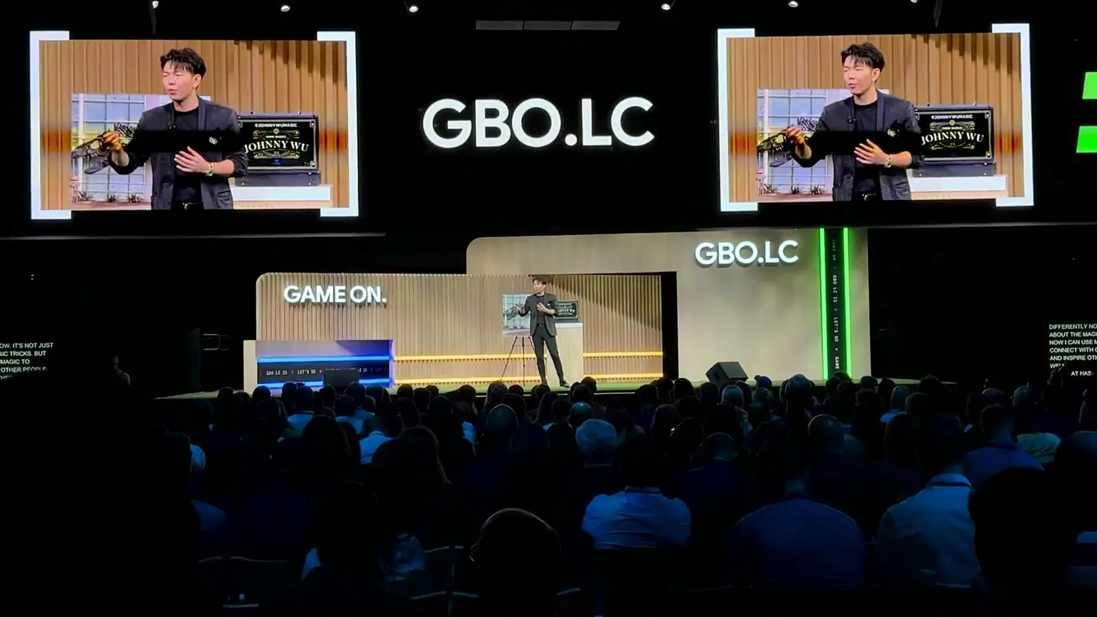 Johnny Wu performing on stage at Google HQ in front of about 700 executives, with the GBO wall behind him